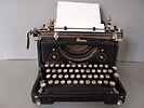En gammal manuell skrivmaskin. Ett papper sitter i valsen.